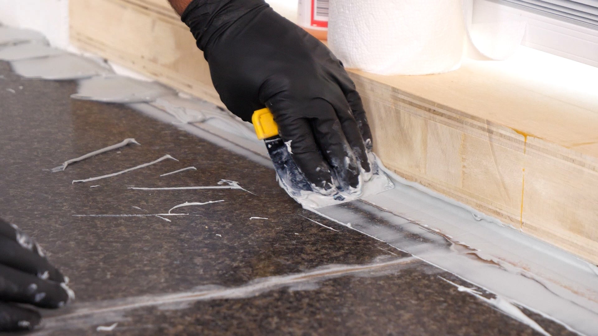 Hand smoothing out a filler on the countertop