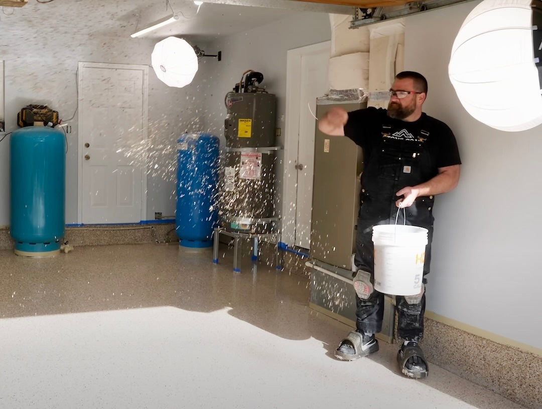Man applying epoxy flakes on a floor