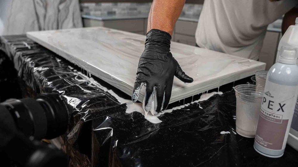 gloved hand melding polyaspartic carrara marble finish