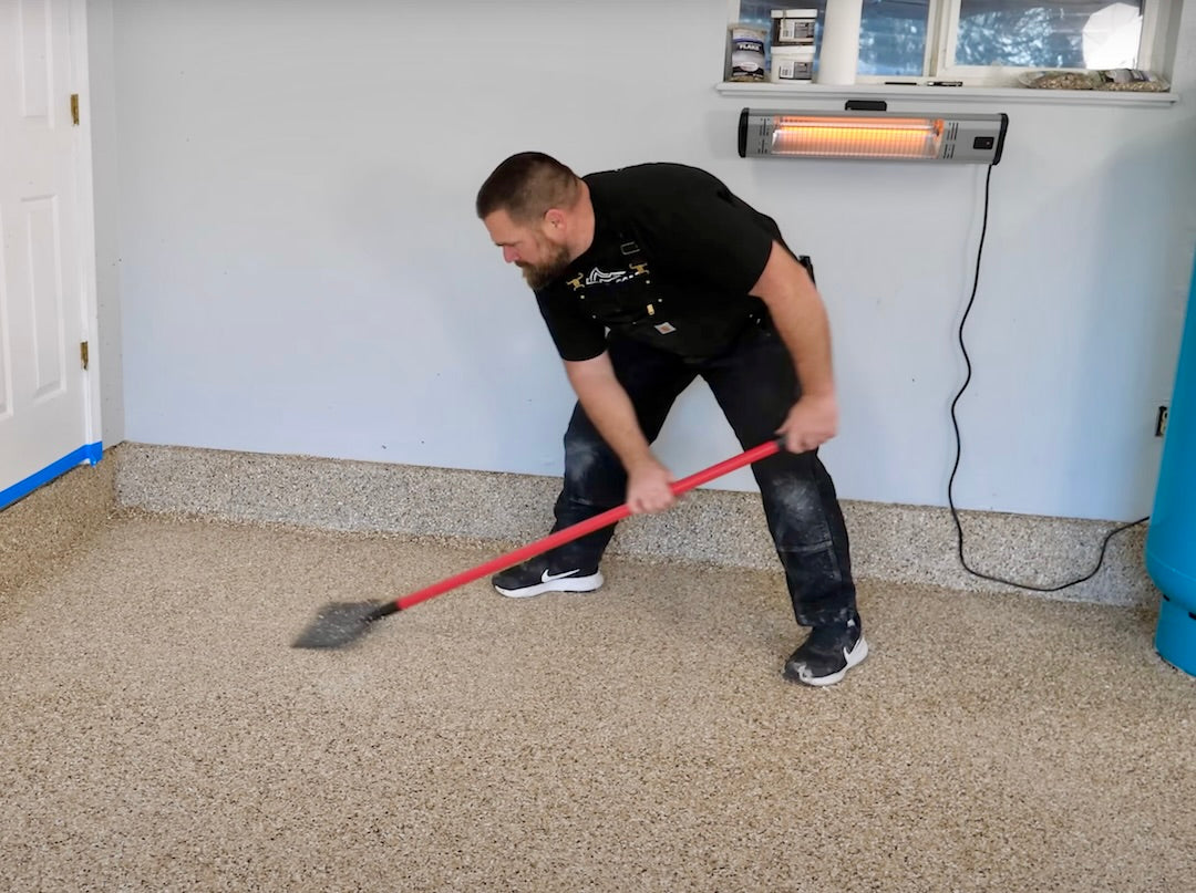 Man scraping epoxy flakes from the floor