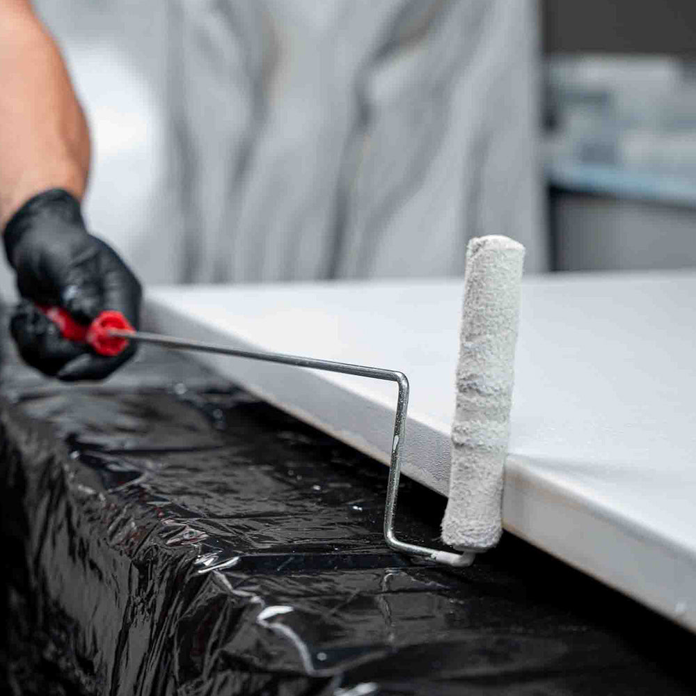 Person rolling APEX Poly Fuse primer onto a countertop edge.