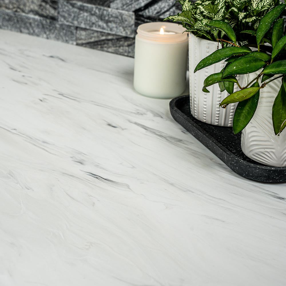 Candle and potted plant on a carrara white marble surface
