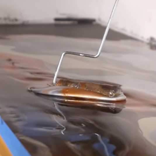 A paint roller smoothing out epoxy on a countertop