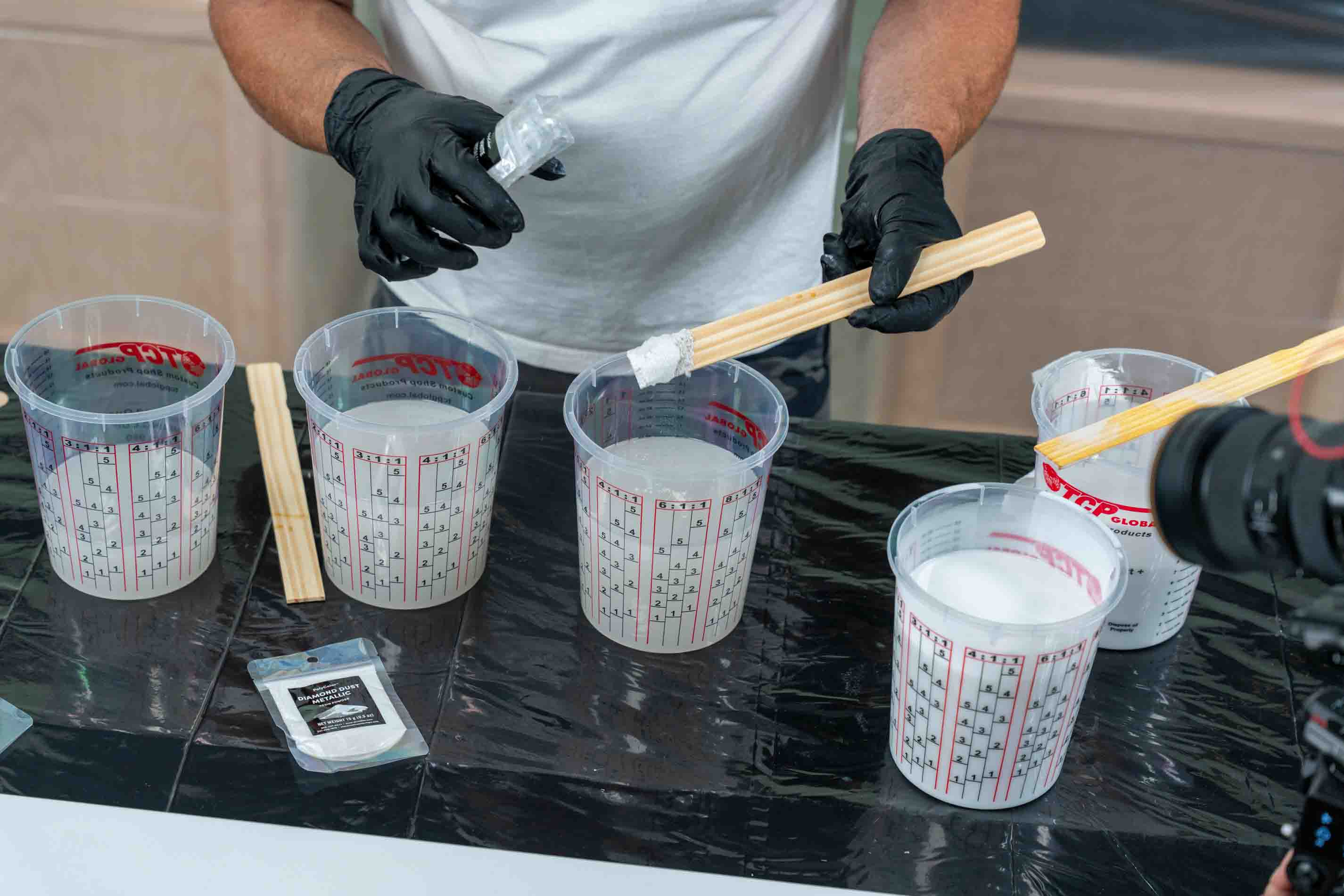 Measuring diamond dust with a paint stick edge to mix white exotic marble