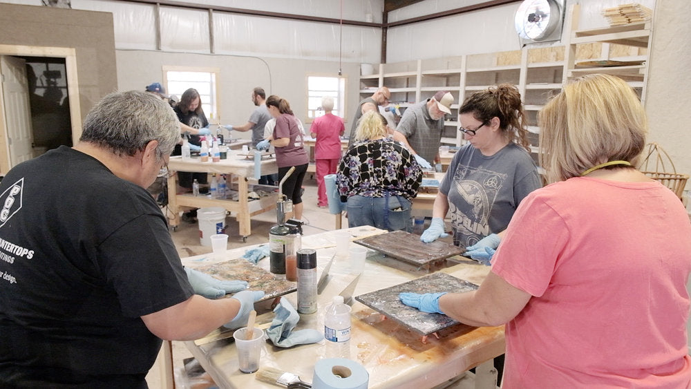 People in a worksop working on an epoxy painting