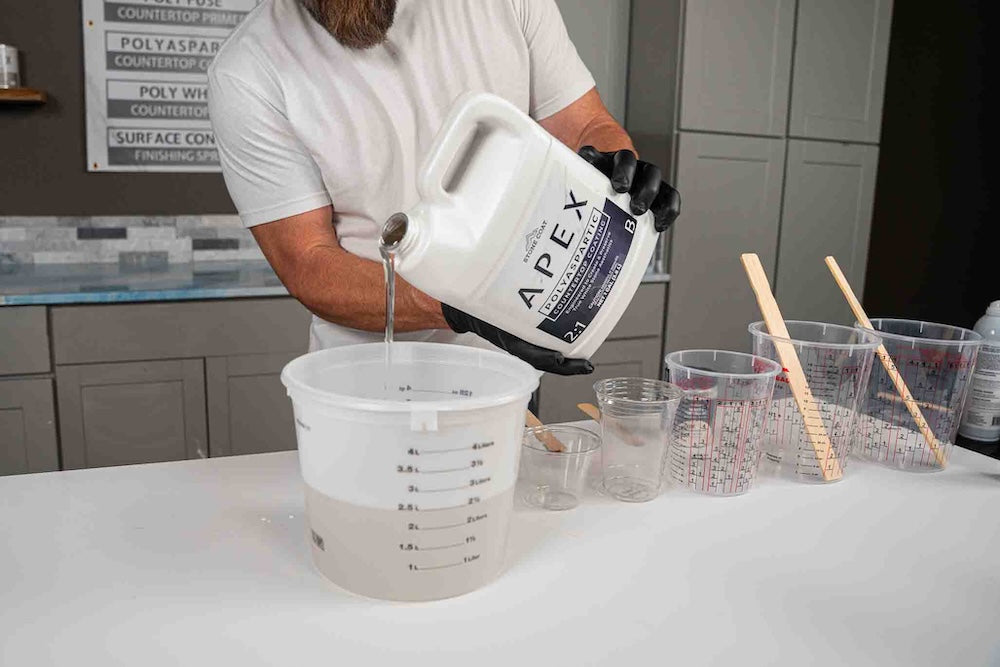 man pouring APEX polyaspartic into large bucket
