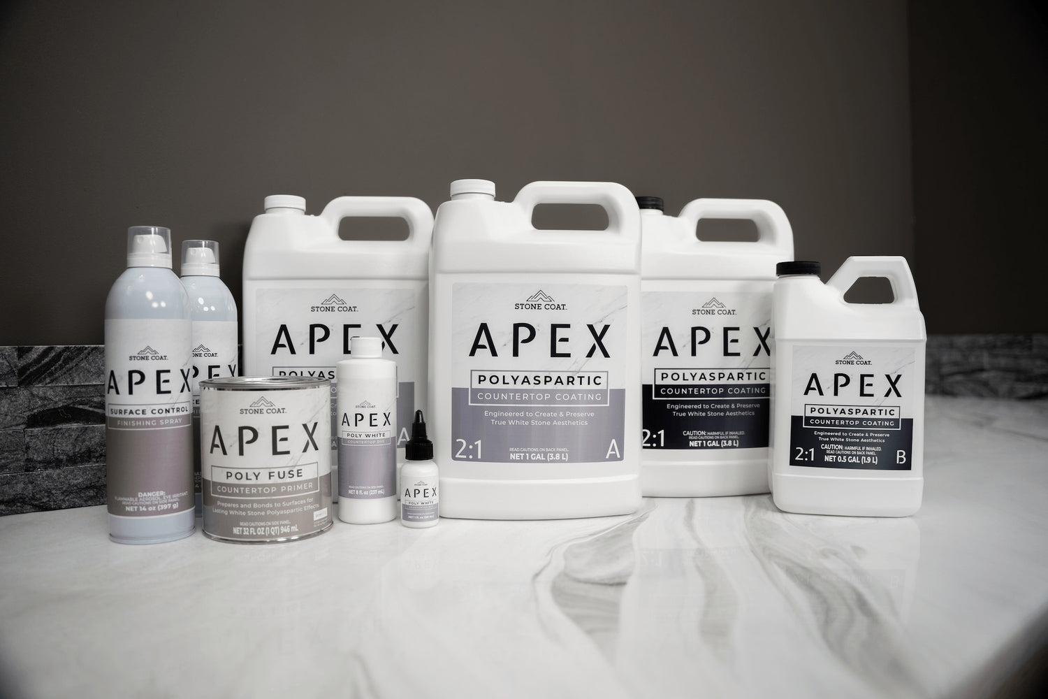 Collection of APEX polyaspartic products on a gray background